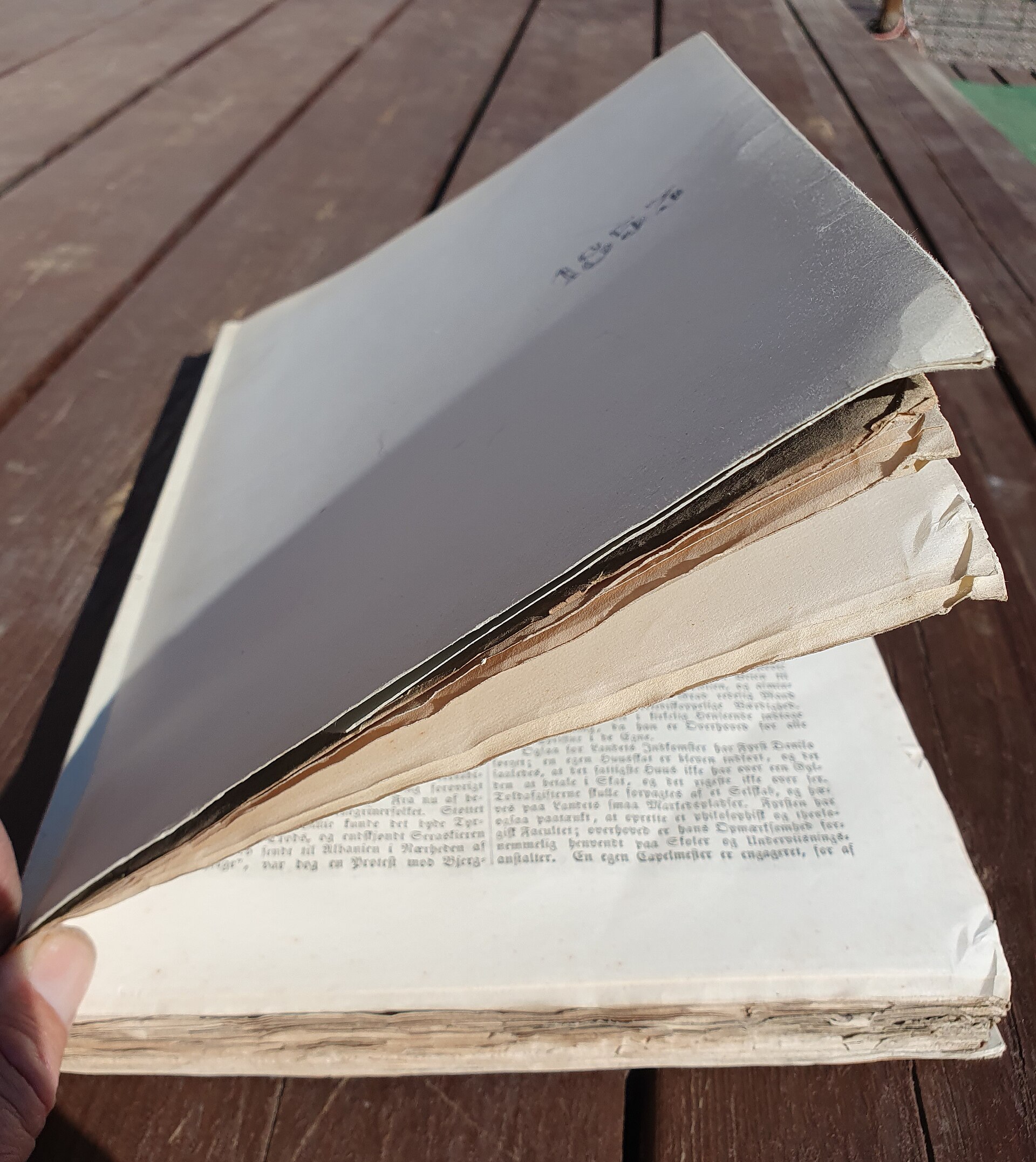 Руки держат расшитый книжный блок со свободными тетрадями перед пересшивкой